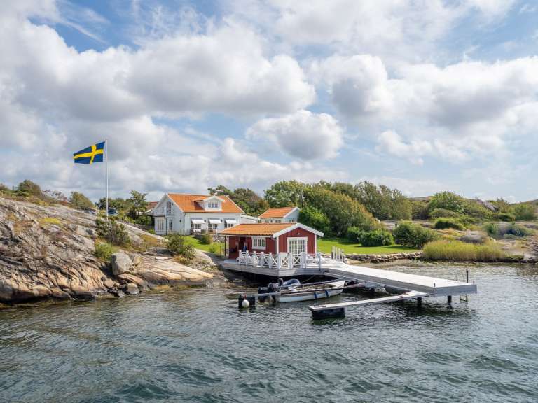 Ein rot-weißes Haus mit einer schwedischen Flagge davor