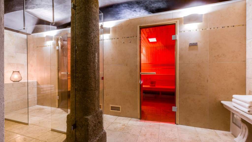 Eine Sauna mit einer roten Tür und einer Dusche