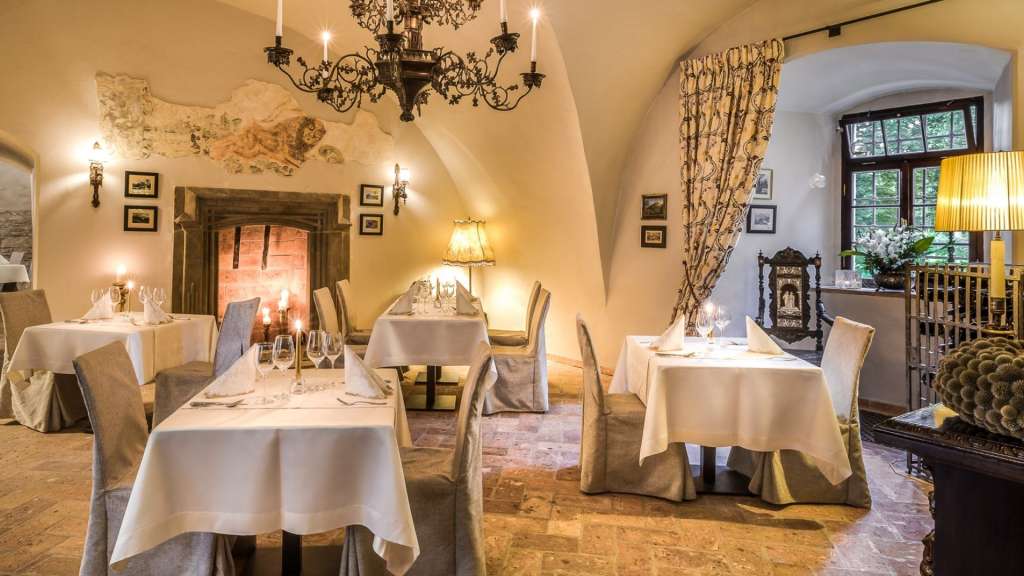 Ein Esszimmer mit Tischen und Stühlen und einem Kamin