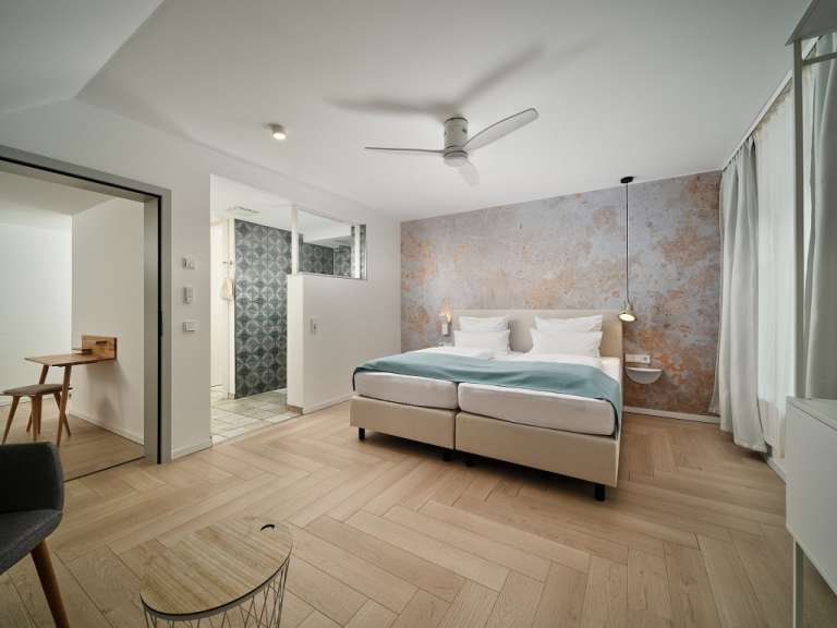 Ein Schlafzimmer mit einem Bett und einem Deckenventilator