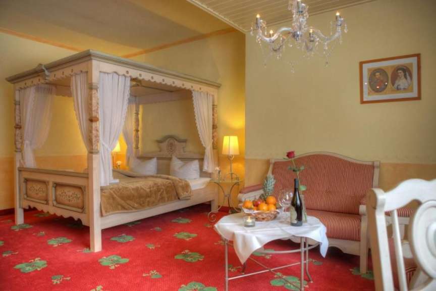 Ein Schlafzimmer mit einem Himmelbett und einem Couchtisch