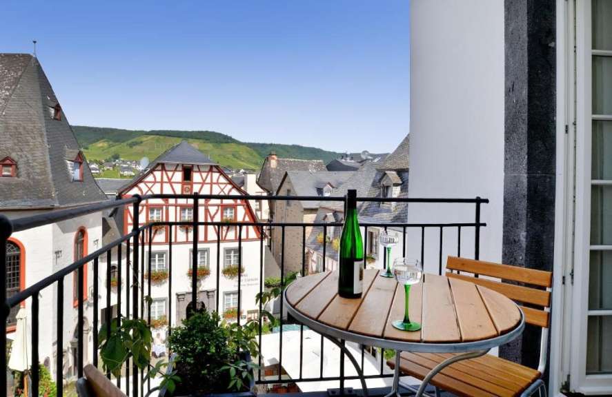Eine Flasche Wein sitzt auf einem Tisch auf einem Balkon