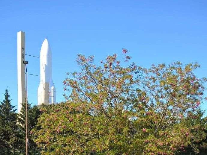 Eine Rakete steht hinter einem Baum mit rosa Blüten