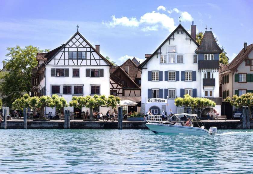 Ein weißes Boot fährt vor einem Gebäude mit der Aufschrift gottlieben