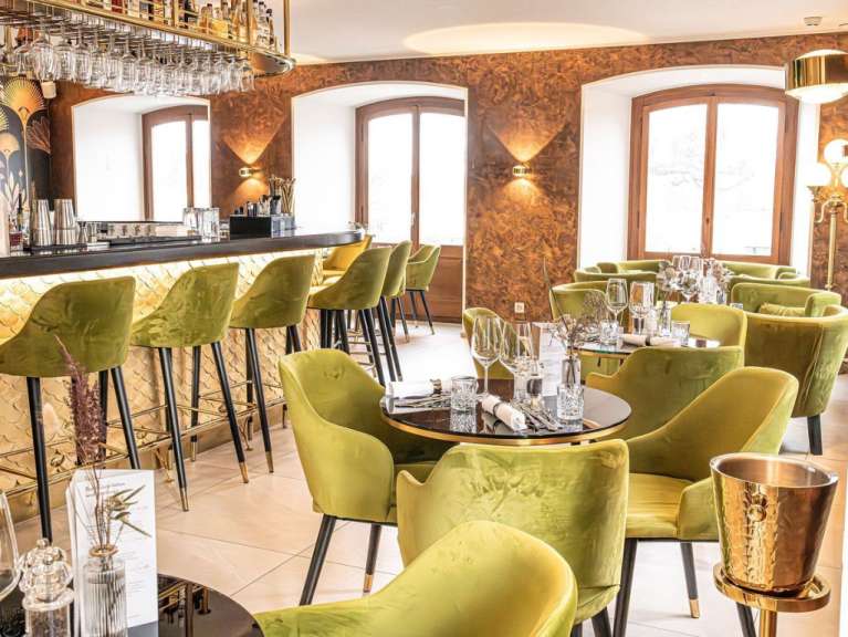 Ein Restaurant mit grünen Stühlen und einer Bar