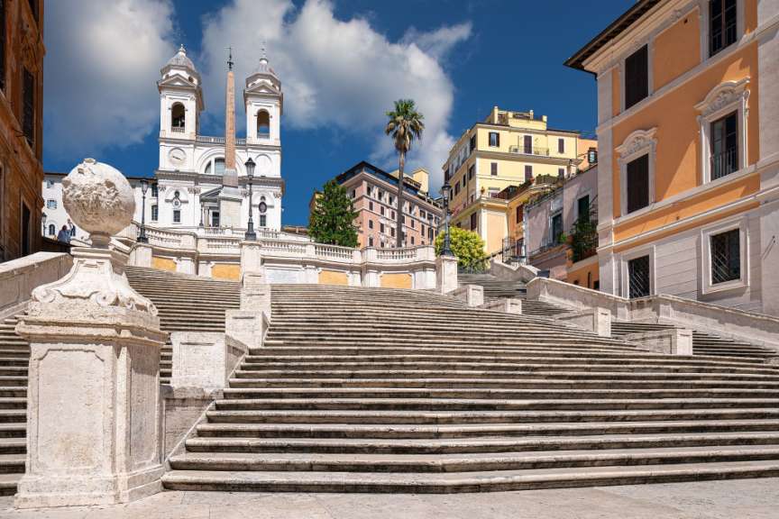 Eine Treppe führt hinauf zu einem Gebäude mit einer Uhr darauf