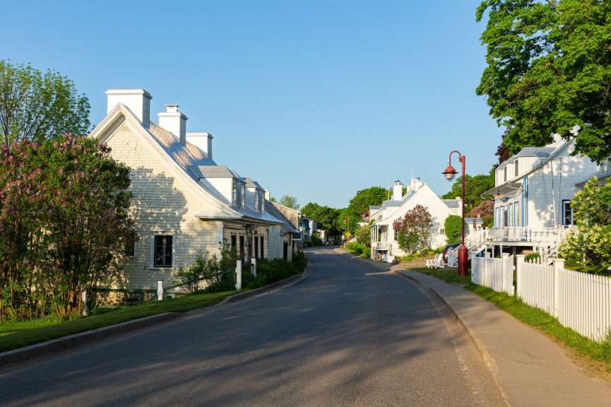 Eine Straße mit weißen Häusern und einem weißen Zaun