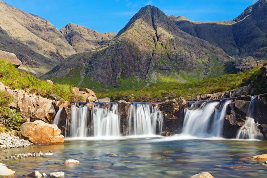 Ein Wasserfall in einem Tal mit Bergen im Hintergrund
