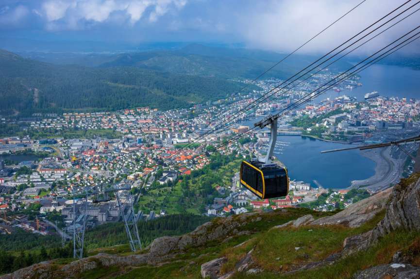Eine Seilbahn fährt über eine Stadt mit einem See im Hintergrund