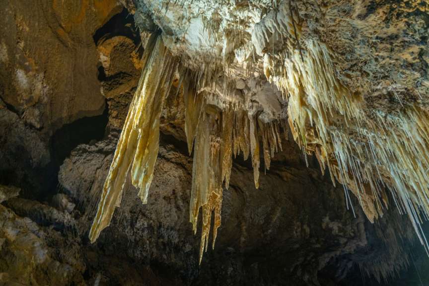 In einer Höhle hängen riesige Eiszapfen an der Decke
