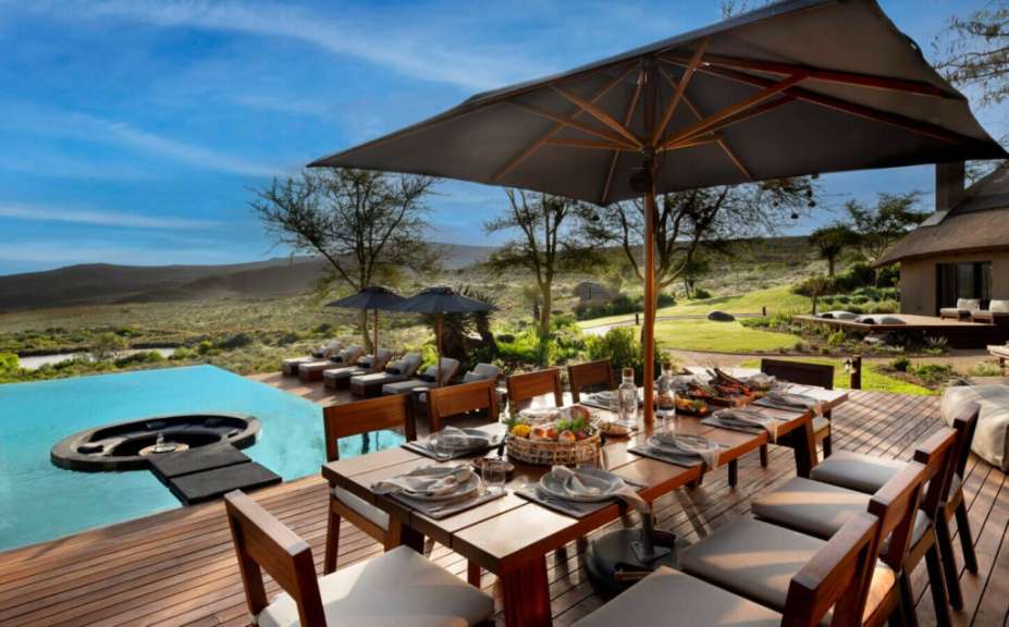 Ein Tisch und Stühle auf einer Terrasse mit Blick auf einen Pool