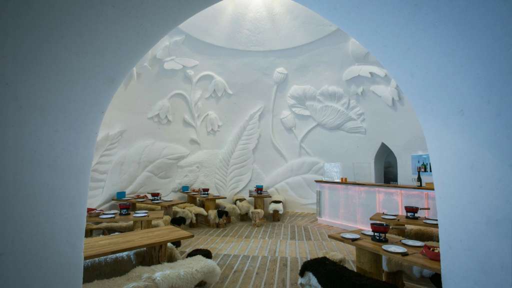 Ein Raum mit Tischen und Stühlen aus Holz und einem Wandbild aus Schnee