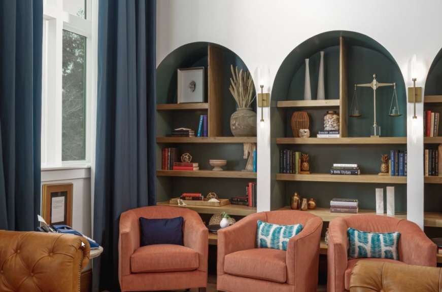 Ein Wohnzimmer mit Stühlen und Bücherregalen mit einem Buch , das auf einem Regal steht