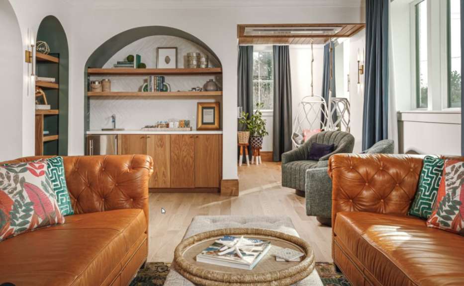 Ein Wohnzimmer mit braunen Ledersofas und grünen Stühlen