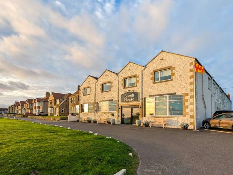 Ein großes weißes Gebäude mit der Aufschrift beach house darauf