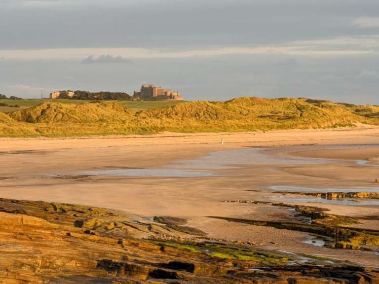 Ein Strand mit einem großen Schloss im Hintergrund