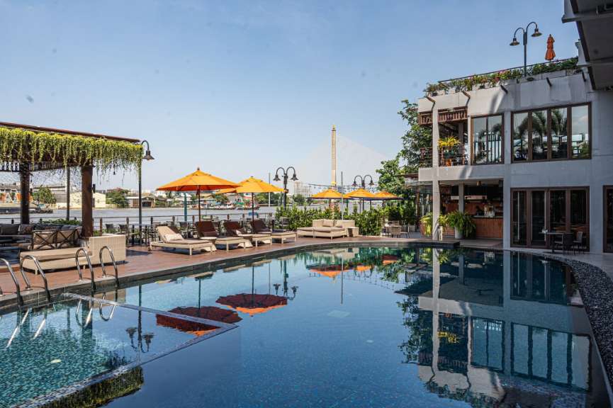Ein großer Swimmingpool mit Liegestühlen und Sonnenschirmen umgeben