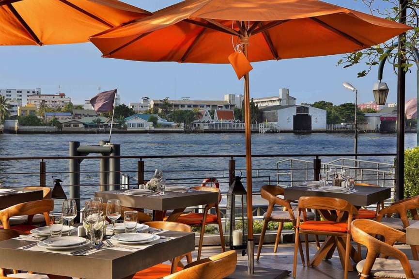 Tische und Stühle in einem Restaurant mit Blick auf den Fluss
