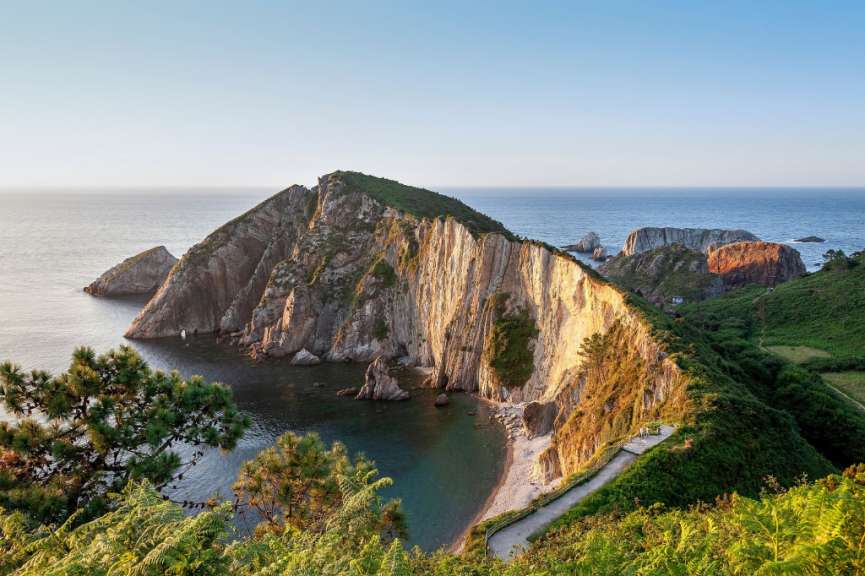 Eine Straße führt an einer Klippe ins Meer