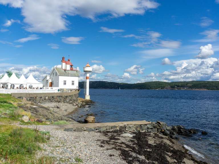 Ein Leuchtturm steht am Ufer eines Sees