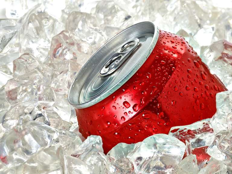 Eine rote Dose cola sitzt auf Eiswürfeln