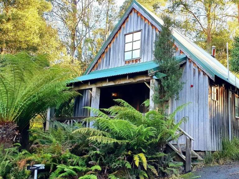 Ein kleines Holzhaus mit einem grünen Dach