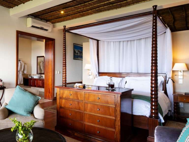 Ein Schlafzimmer mit einem Himmelbett und einer Kommode