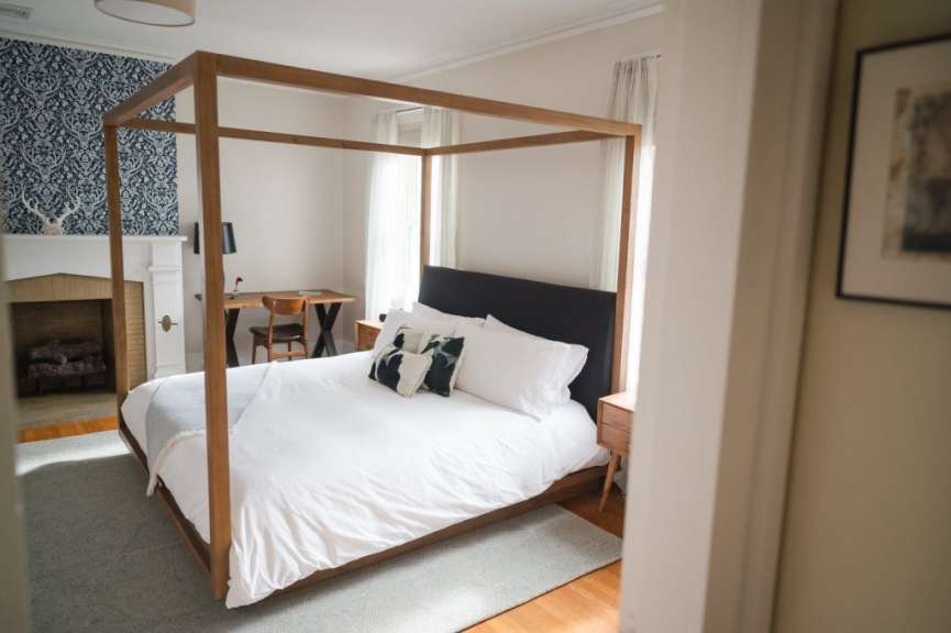 Ein Schlafzimmer mit einem Himmelbett und einem Kamin