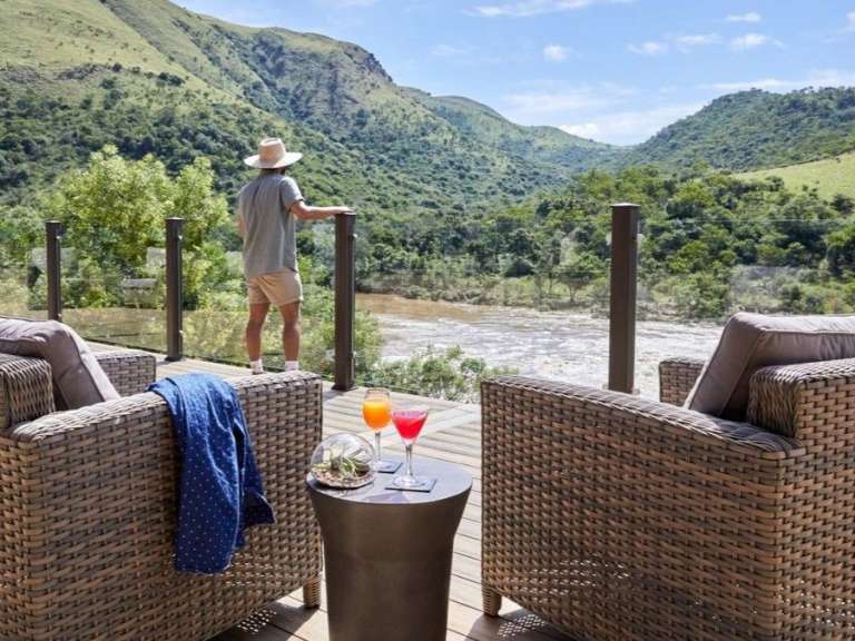 Ein Mann steht auf einem Deck mit Blick auf einen Fluss