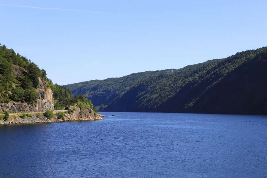 Ein großer blauer See umgeben von Bergen und Bäumen