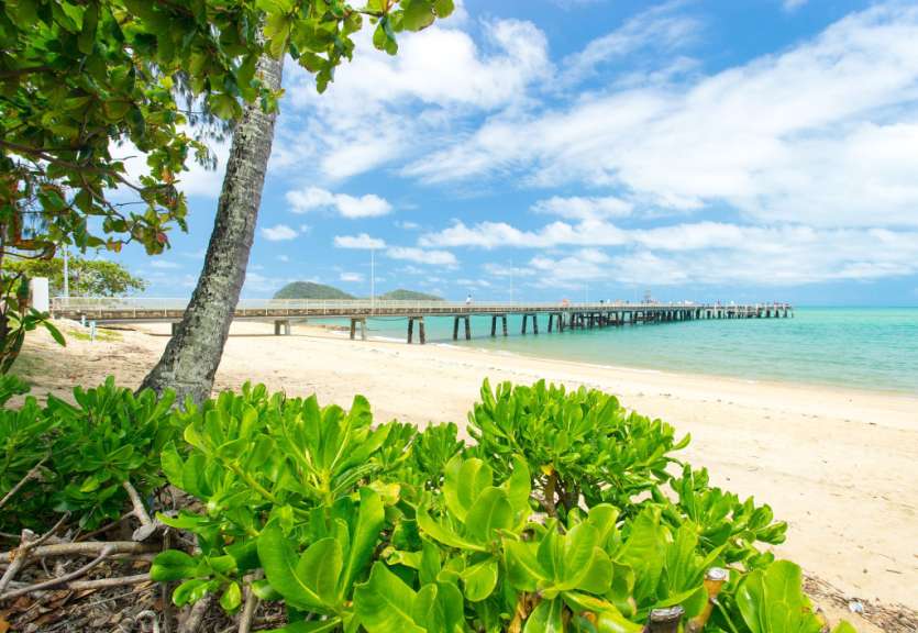 Ein Strand mit einer Brücke in der Ferne