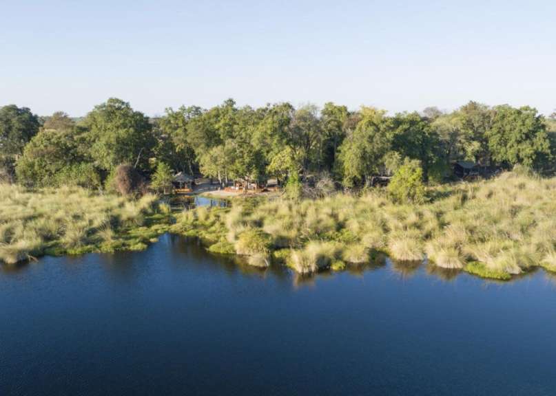 Ein großer See umgeben von Bäumen und Gras