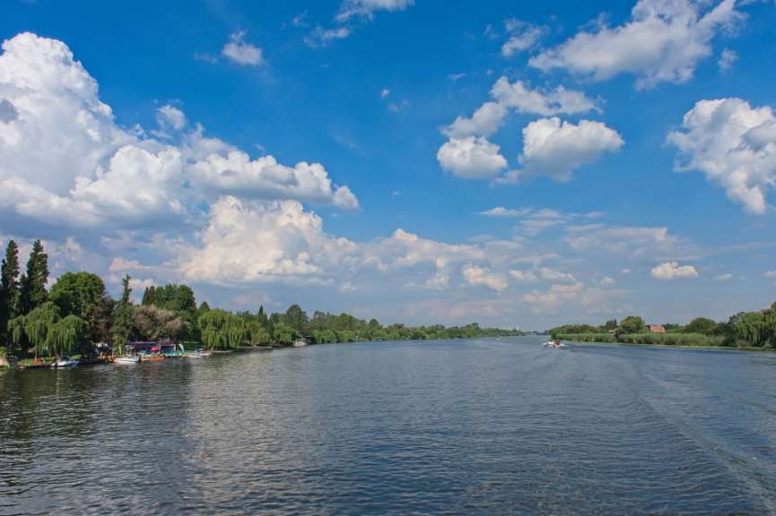 Ein Fluss mit einem blauen Himmel und weißen Wolken