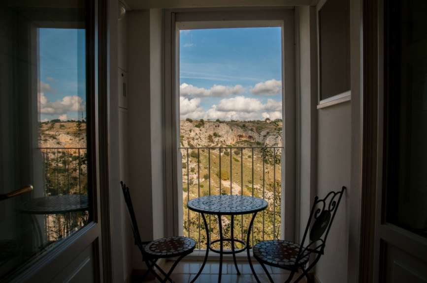 Ein Tisch und Stühle auf einem Balkon mit Blick auf die Landschaft