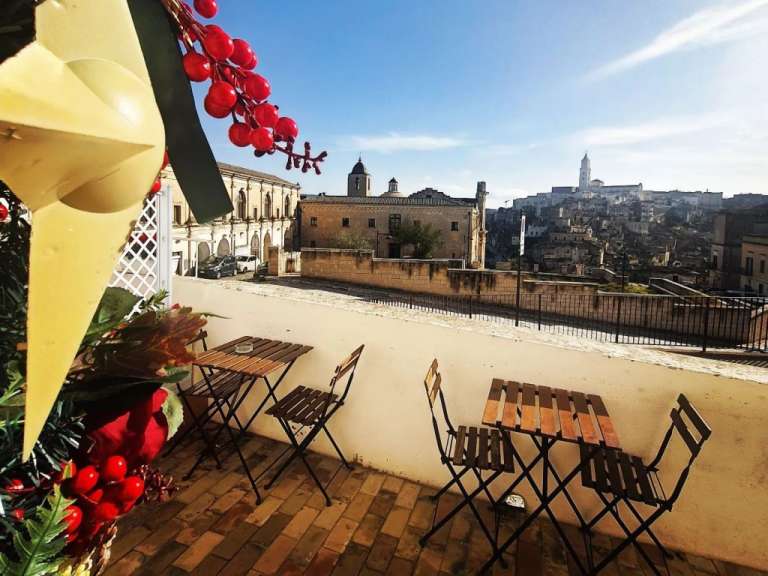 Ein Tisch und Stühle auf einem Balkon mit einem Gebäude im Hintergrund