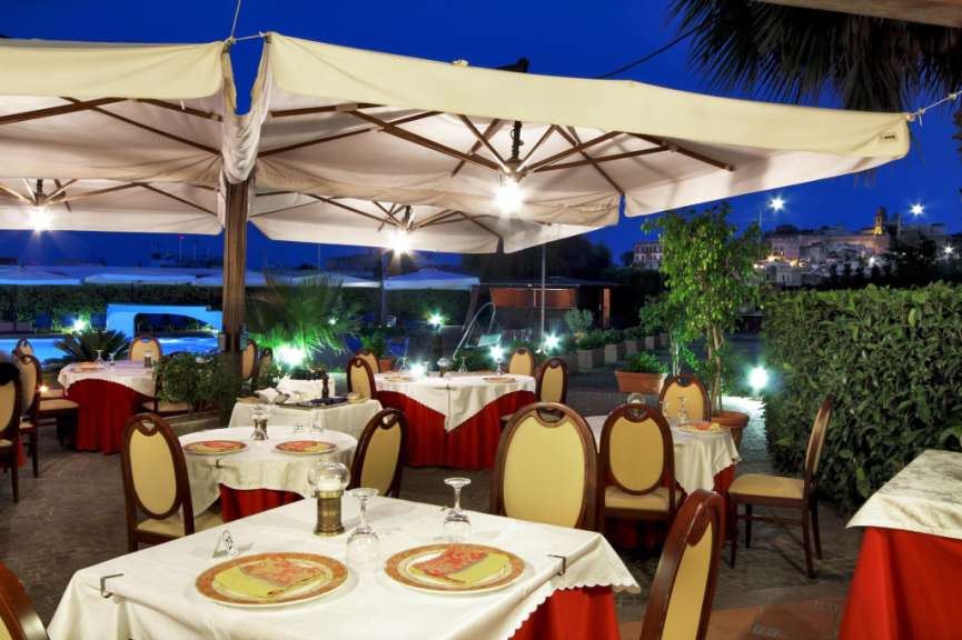 Tische und Stühle in einem Restaurant mit Regenschirmen