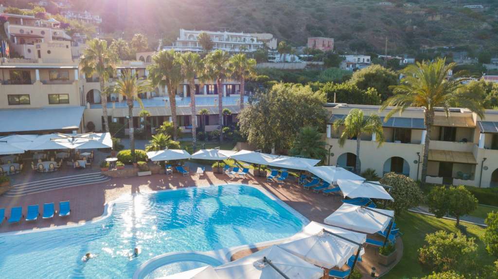 Ein großer Swimmingpool umgeben von Sonnenschirmen und Stühlen
