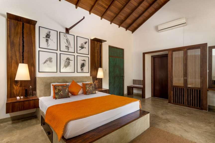 Ein Schlafzimmer mit einem Bett und Bildern von Vögeln an der Wand
