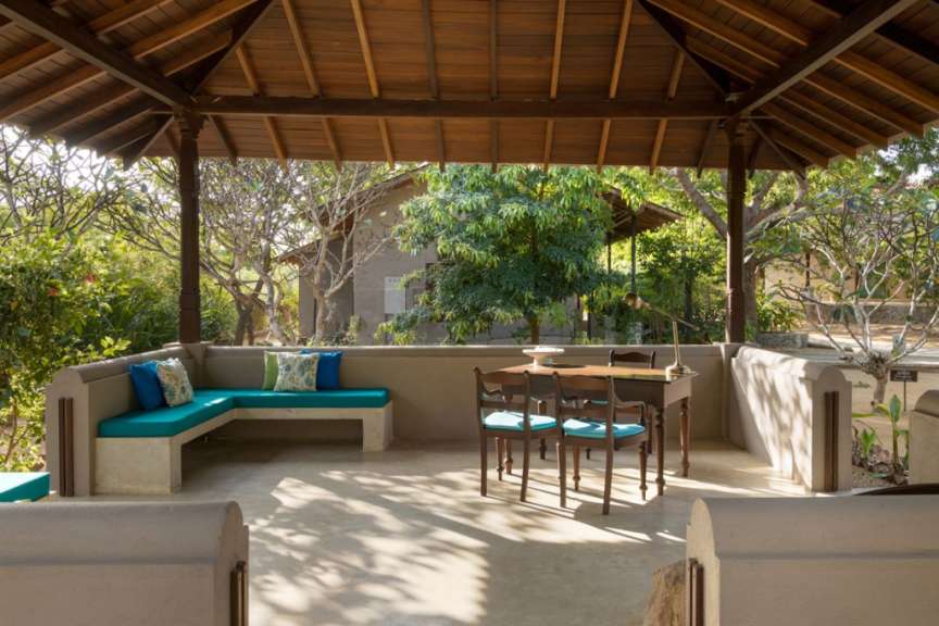 Eine Terrasse mit einem Tisch und Stühlen unter einem Holzdach