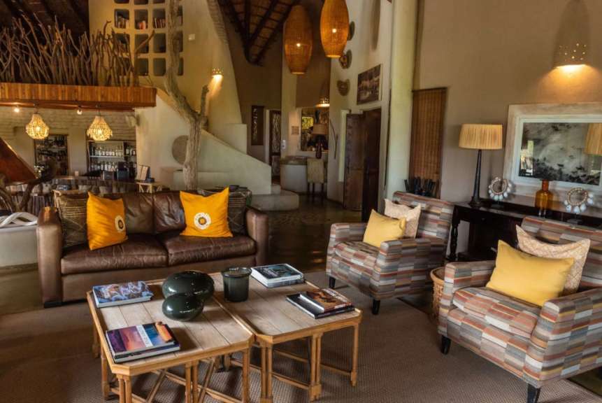 Ein Wohnzimmer mit einem braunen Ledersofa und gelben Kissen