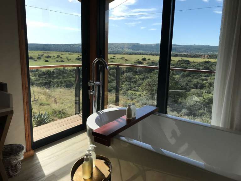 Ein Badezimmer mit einer Badewanne und einem großen Fenster