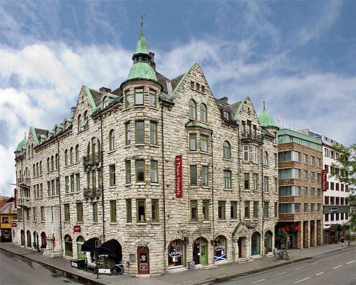Ein großes Steingebäude mit einem grünen Turm und einem roten Schild, das sagt ‚ norwegian house ‘