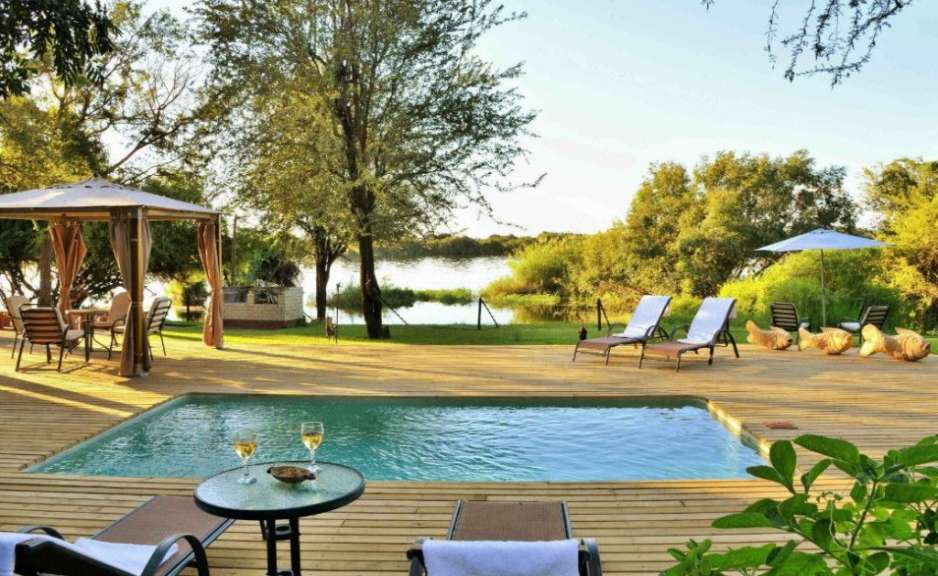 Ein Holzdeck mit einem Swimmingpool und Liegestühlen