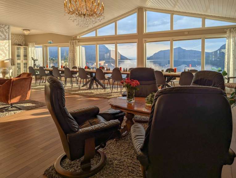Ein Wohnzimmer mit vielen Stühlen und einem Tisch