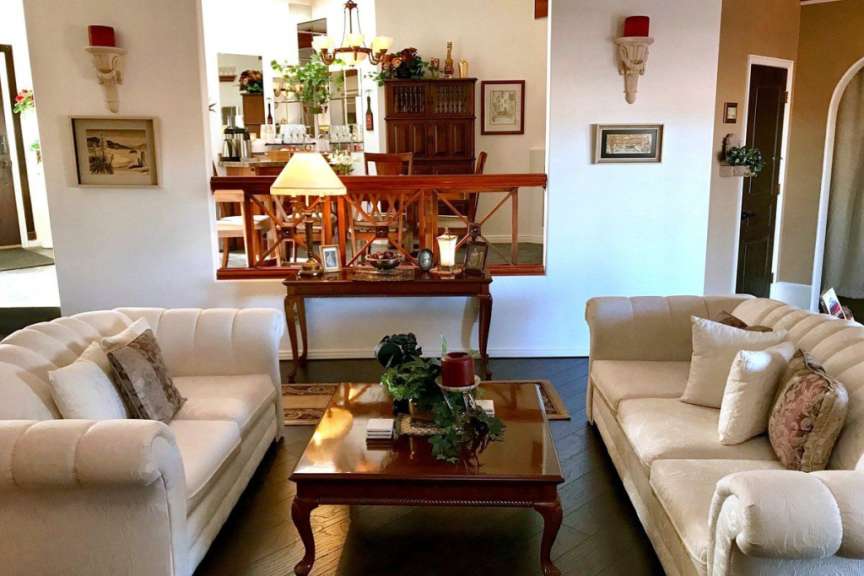 Ein Wohnzimmer mit zwei weißen Sofas und einem Holztisch