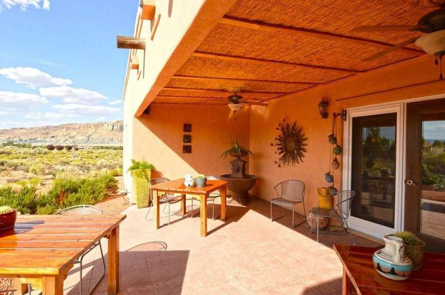Eine Terrasse mit Tisch und Stühlen und einem Deckenventilator