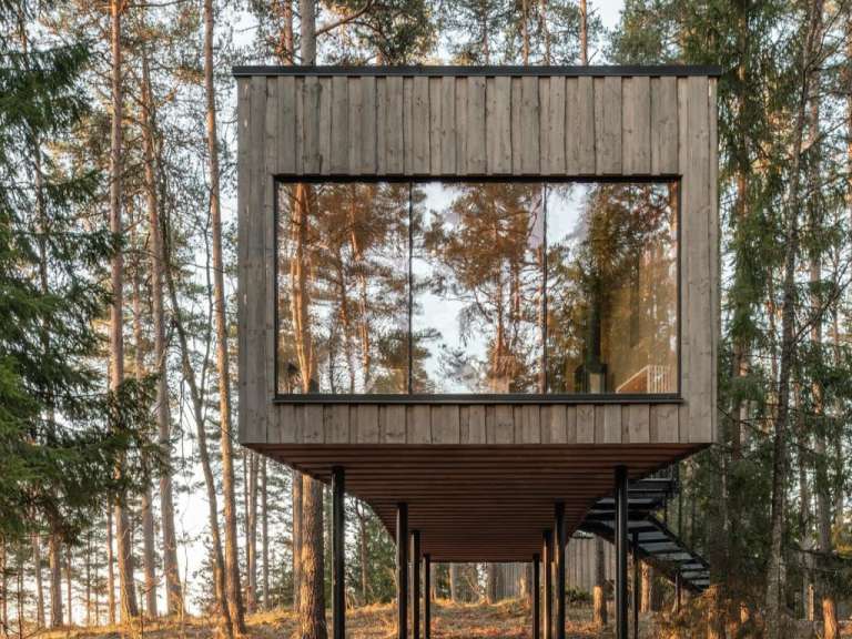 Ein kleines Holzhaus mit einer Treppe im Wald