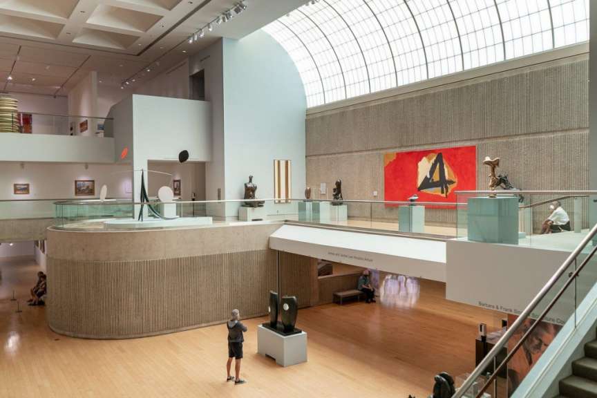 Ein Mann steht in einem Museum und schaut auf ein Gemälde