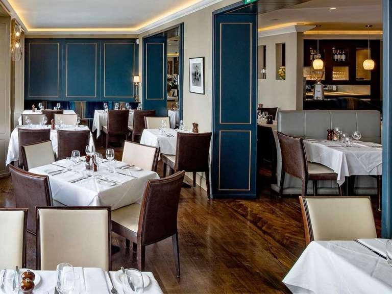 Die Inneneinrichtung eines Restaurants mit gedeckten Tischen und Sitzgelegenheiten.