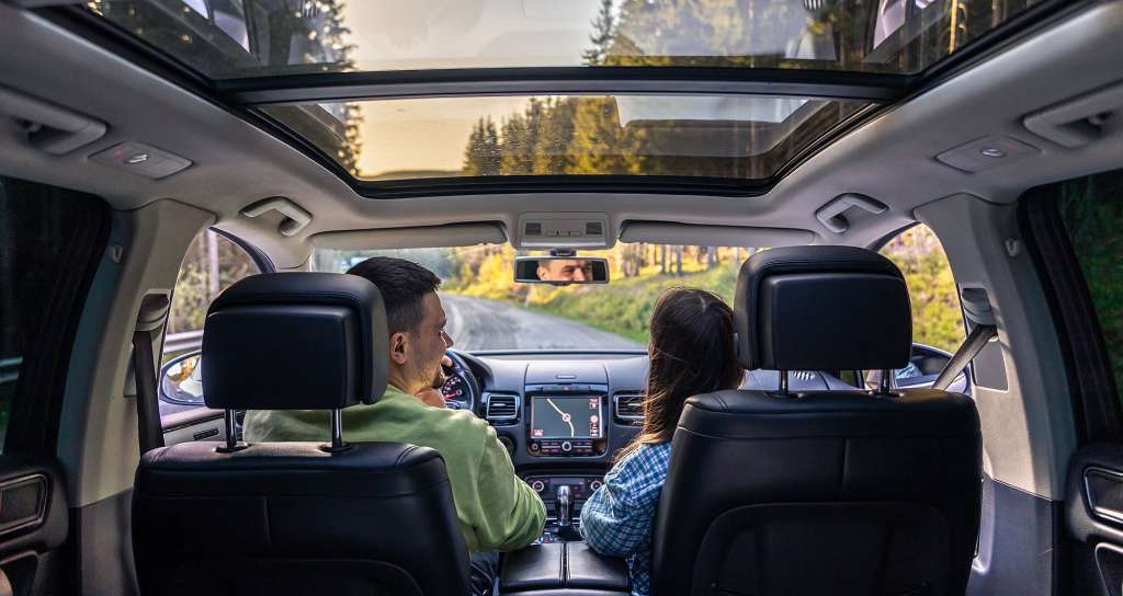 Ein Mann und eine Frau fahren in einem Auto mit einem Sonnendach